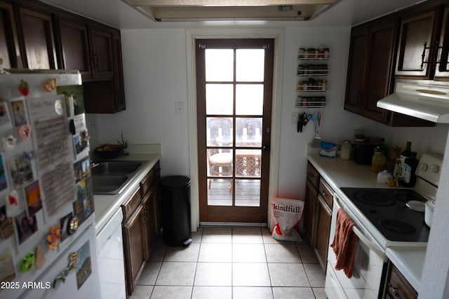 kitchen featuring under cabinet range hood, white appliances, light countertops, and light tile patterned floors
