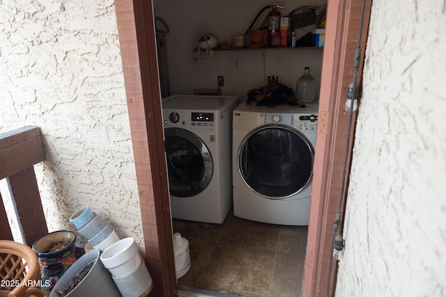 clothes washing area featuring laundry area, separate washer and dryer, and dark tile patterned floors
