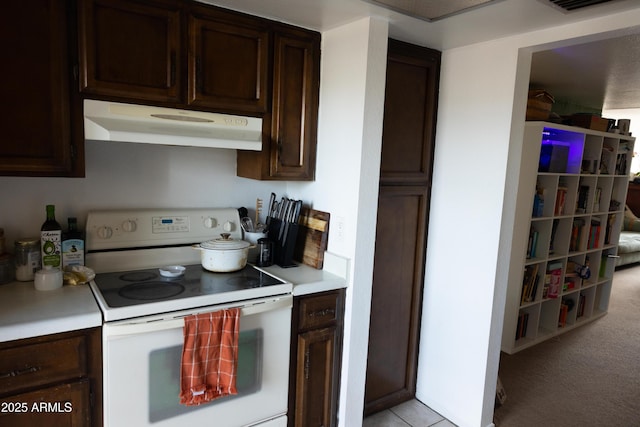 kitchen featuring dark brown cabinetry, electric stove, under cabinet range hood, light countertops, and light carpet