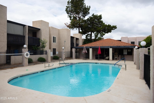 pool featuring a patio area and fence