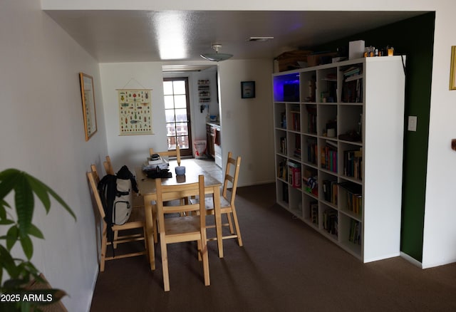 carpeted dining room with baseboards