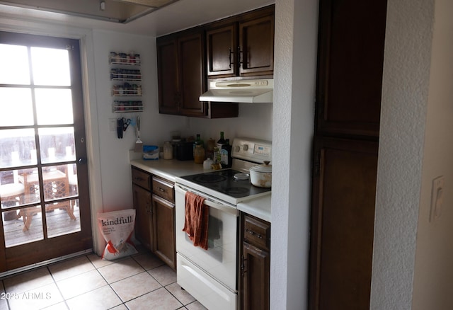 kitchen with under cabinet range hood, dark brown cabinets, light tile patterned flooring, white range with electric cooktop, and light countertops