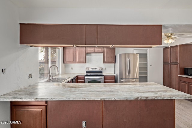 kitchen with sink, kitchen peninsula, ceiling fan, and appliances with stainless steel finishes