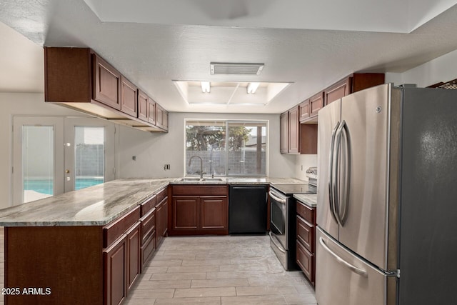 kitchen featuring a raised ceiling, sink, light hardwood / wood-style floors, kitchen peninsula, and stainless steel appliances