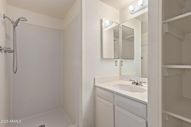 bathroom with vanity and a shower