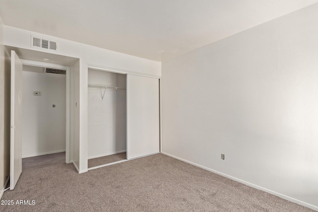 unfurnished bedroom featuring carpet and a closet