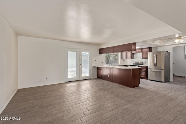 kitchen featuring dark brown cabinetry, stainless steel appliances, kitchen peninsula, and ceiling fan