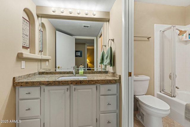 full bathroom featuring enclosed tub / shower combo, vanity, and toilet