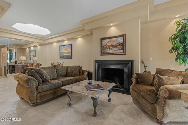 living room featuring a high end fireplace and a skylight