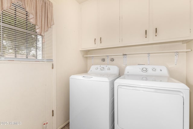 laundry area with washing machine and dryer and cabinets