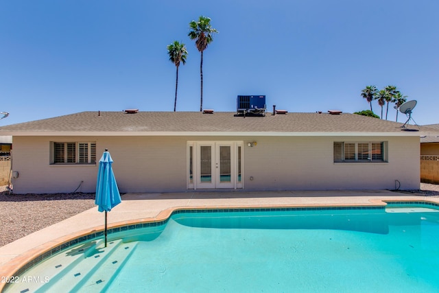 view of swimming pool featuring central AC and french doors