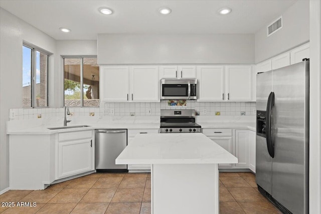 1453 E S Fork Dr, Phoenix, AZ 85048 - kitchen featuring appliances with stainless steel finishes, a sink, backsplash, a center island, and white cabinetry