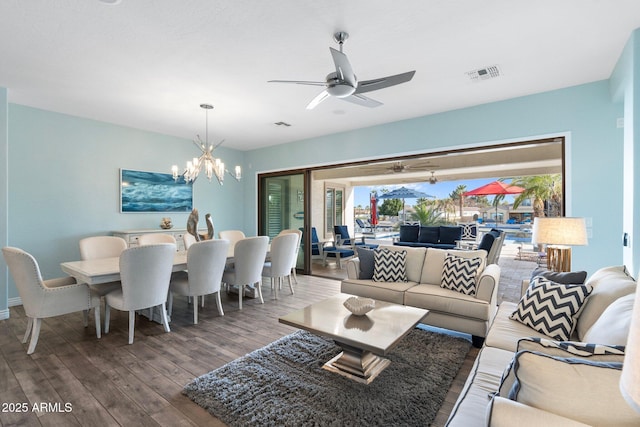 living room featuring hardwood / wood-style flooring and ceiling fan with notable chandelier