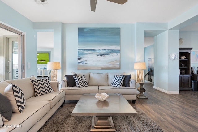 living room featuring dark wood-type flooring and ceiling fan