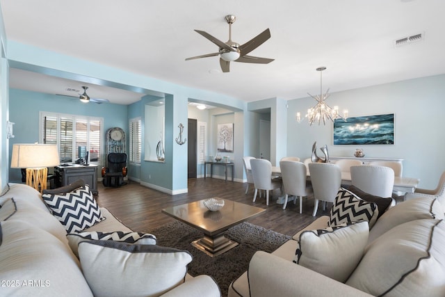 living room featuring dark hardwood / wood-style flooring and ceiling fan with notable chandelier