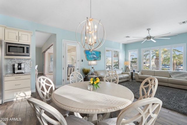 dining room featuring ceiling fan with notable chandelier and light hardwood / wood-style floors