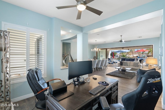 office with ceiling fan with notable chandelier and wood-type flooring