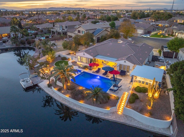 aerial view at dusk featuring a water view