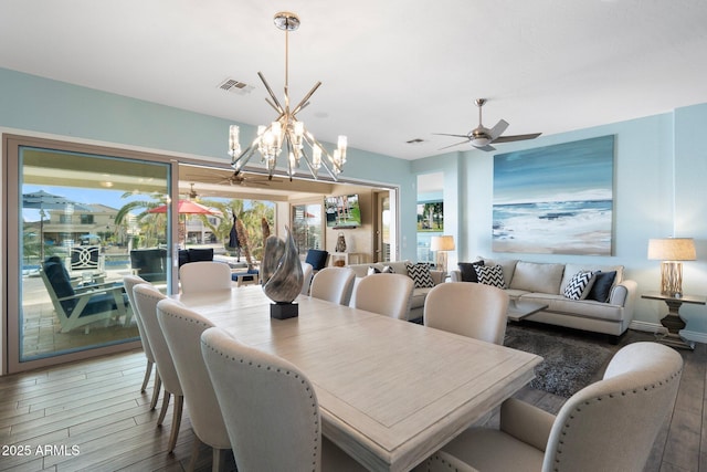 dining area featuring hardwood / wood-style flooring and ceiling fan with notable chandelier