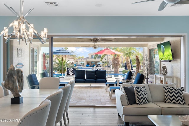 living room featuring hardwood / wood-style floors and ceiling fan with notable chandelier