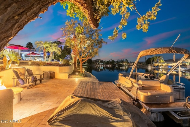 view of dock with a patio area and a water view