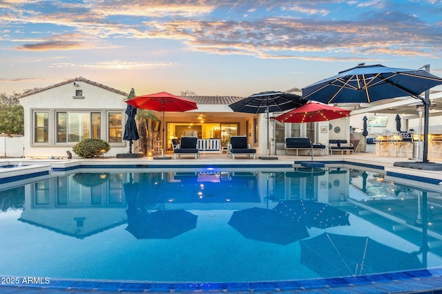 pool at dusk with a patio