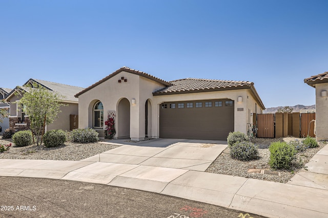 4936 N 194th Dr, Litchfield Park, AZ 85340 - mediterranean / spanish-style house featuring stucco siding, an attached garage, a tile roof, driveway, and a gate