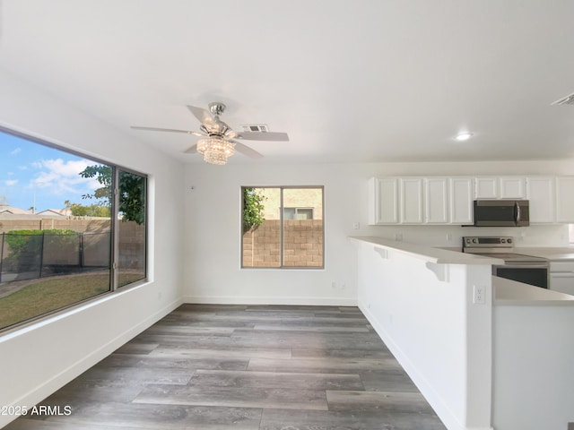 kitchen with visible vents, wood finished floors, white cabinetry, appliances with stainless steel finishes, and light countertops