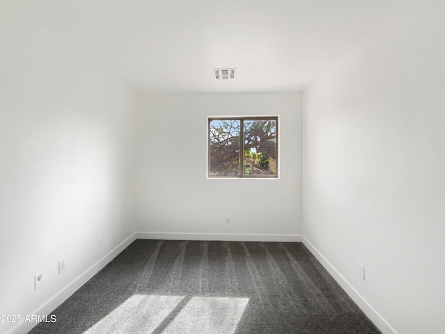 spare room with visible vents, dark carpet, and baseboards