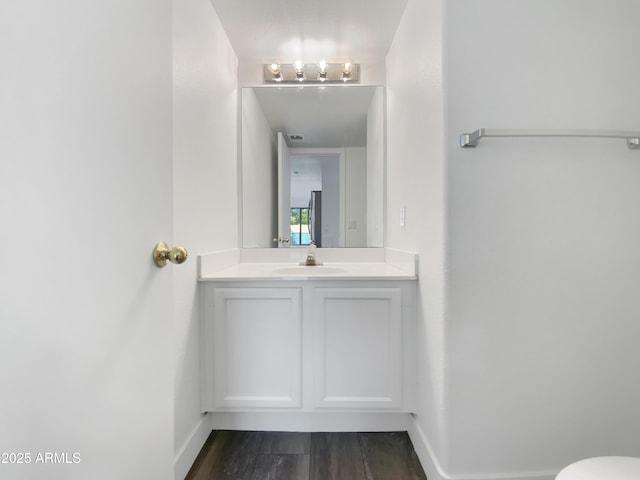 bathroom with visible vents, toilet, wood finished floors, baseboards, and vanity