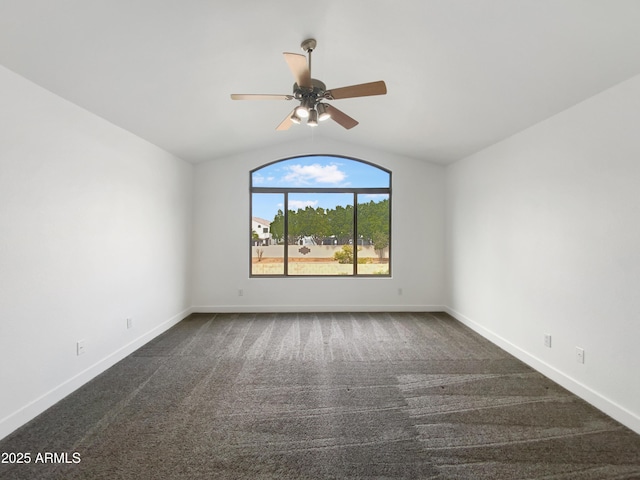 spare room with dark carpet, a ceiling fan, lofted ceiling, and baseboards