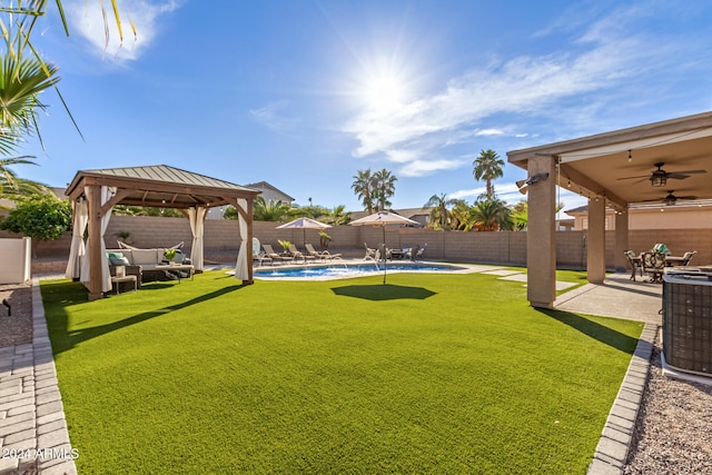 view of yard featuring a gazebo, ceiling fan, a fenced in pool, a patio, and central air condition unit