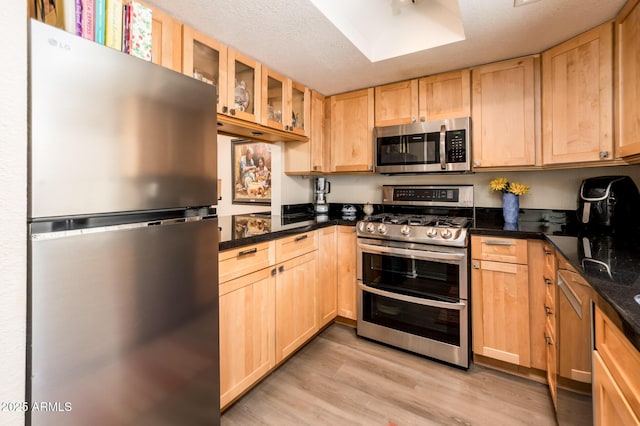 5209 N 78th St, Scottsdale, AZ 85250 - kitchen with stainless steel appliances, light brown cabinets, light wood-type flooring, and glass insert cabinets