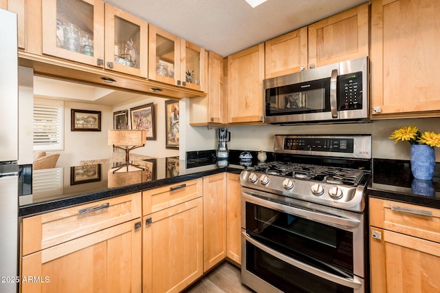 5209 N 78th St, Scottsdale, AZ 85250 - kitchen with stainless steel appliances, light brown cabinetry, glass insert cabinets, and a peninsula