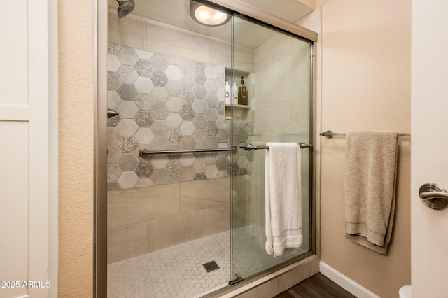 5209 N 78th St, Scottsdale, AZ 85250 - bathroom featuring a stall shower, baseboards, and wood finished floors