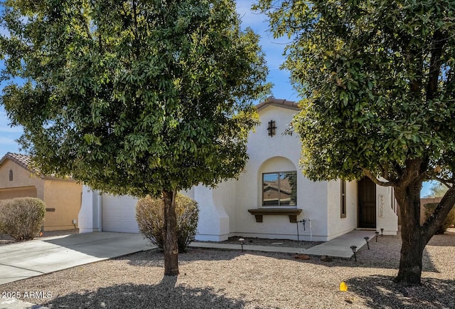 view of front of property featuring driveway, a tiled roof, an attached garage, and stucco siding