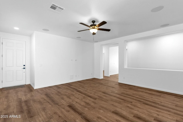 unfurnished room with a ceiling fan, wood finished floors, visible vents, and baseboards