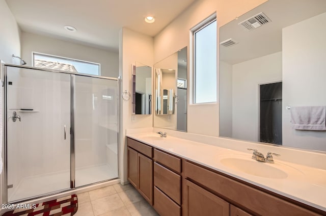 bathroom featuring tile patterned floors, vanity, and a shower with door