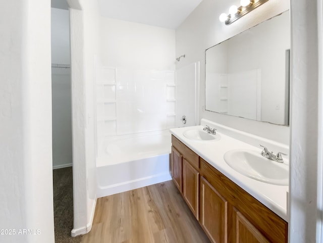 bathroom featuring vanity, wood-type flooring, and washtub / shower combination