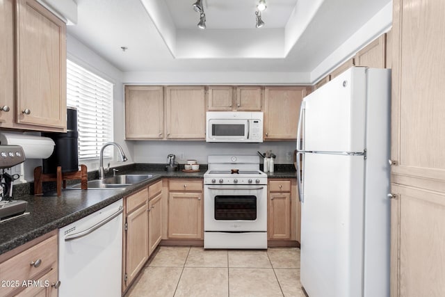 kitchen with light brown cabinetry, sink, light tile patterned floors, a tray ceiling, and white appliances