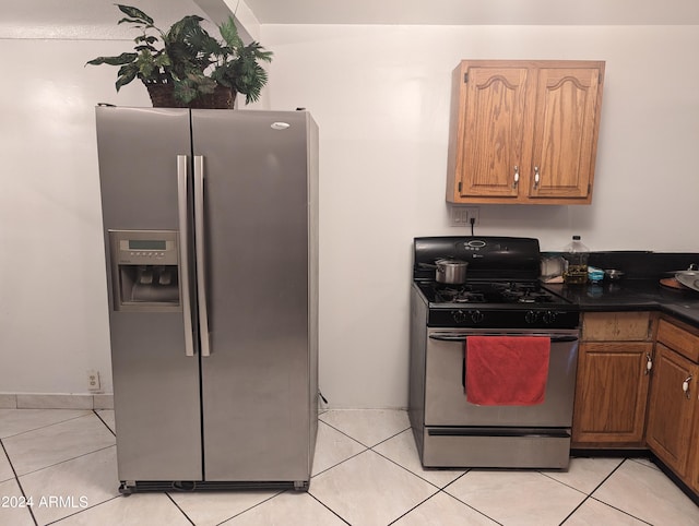 kitchen with range with gas cooktop, light tile floors, and stainless steel fridge