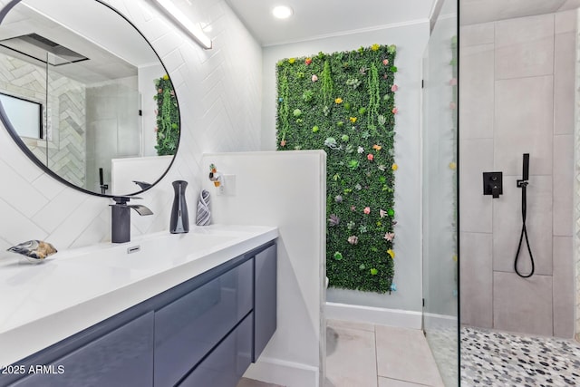 bathroom featuring tiled shower, vanity, tile patterned flooring, and decorative backsplash