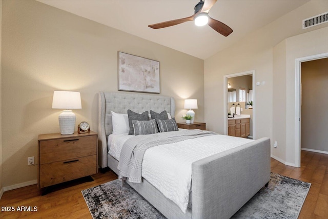 bedroom featuring ensuite bathroom, hardwood / wood-style floors, ceiling fan, and vaulted ceiling