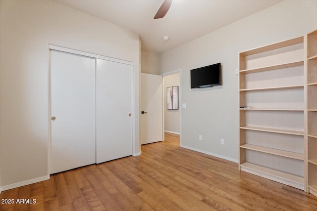 unfurnished bedroom featuring ceiling fan, light hardwood / wood-style floors, and a closet