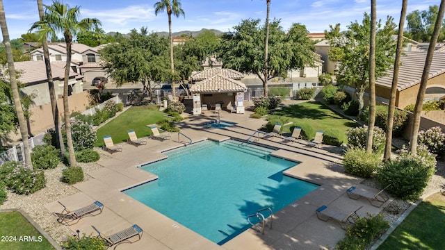 view of pool with a patio area and a yard