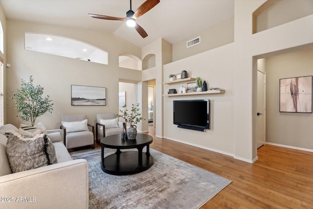 living room featuring ceiling fan, wood-type flooring, and lofted ceiling