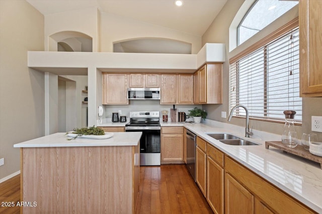 kitchen featuring appliances with stainless steel finishes, a kitchen island, plenty of natural light, and sink