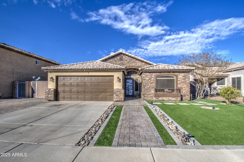 mediterranean / spanish house with a garage and a front lawn