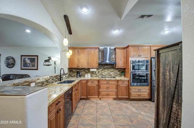 kitchen with wall chimney exhaust hood, sink, hanging light fixtures, decorative backsplash, and black appliances