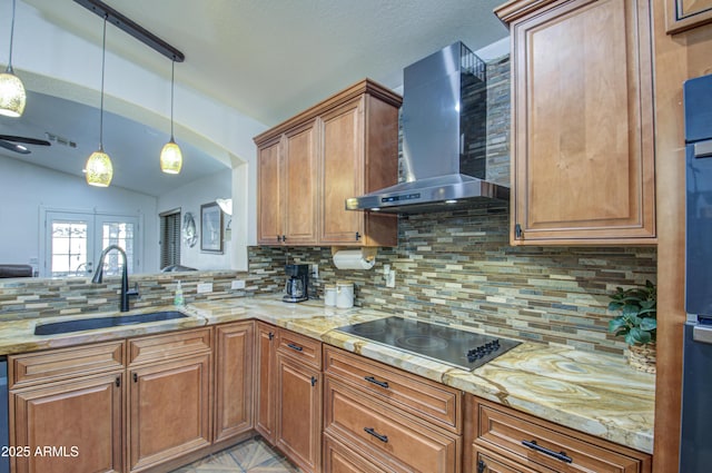 kitchen featuring sink, black electric stovetop, decorative backsplash, and wall chimney exhaust hood